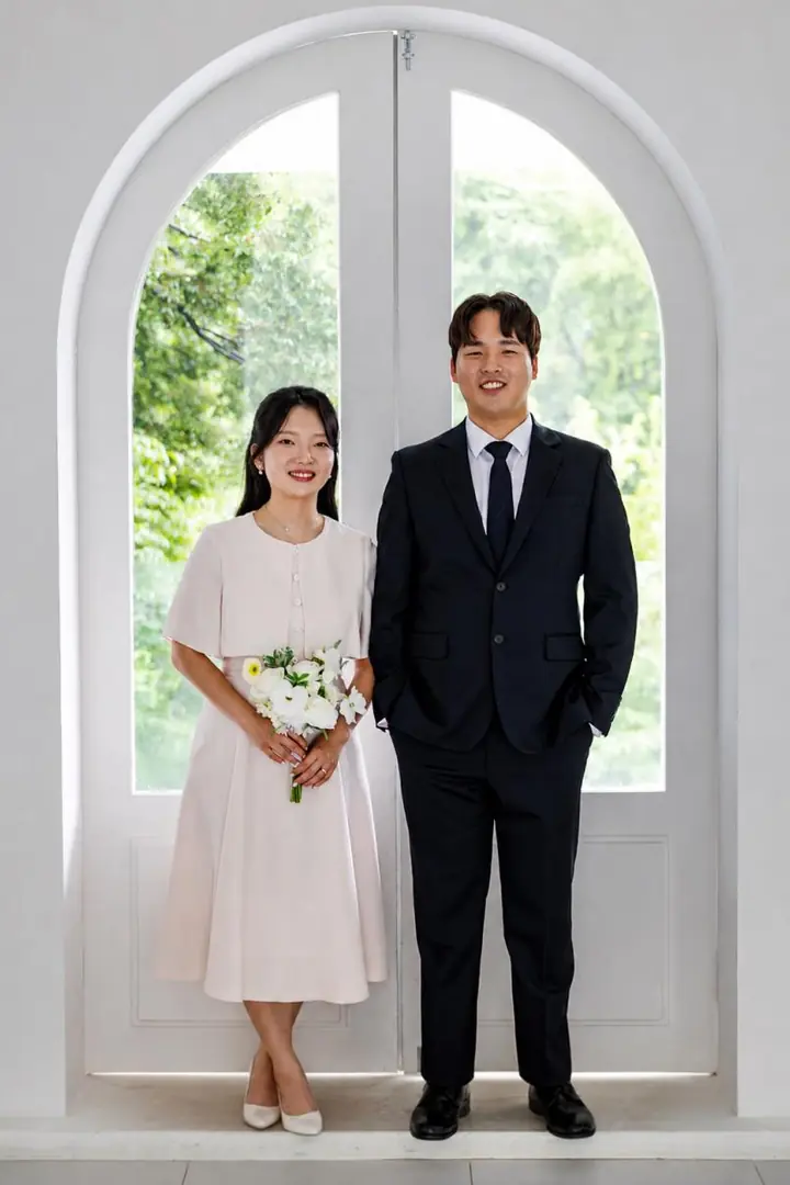 아치 창문 앞에 나란히 선 두 사람