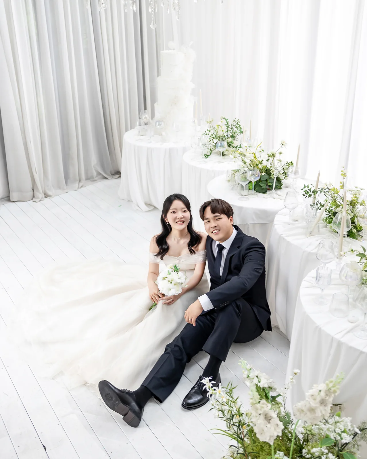하얀 꽃 장식 방 바닥에 나란히 앉은 두 사람