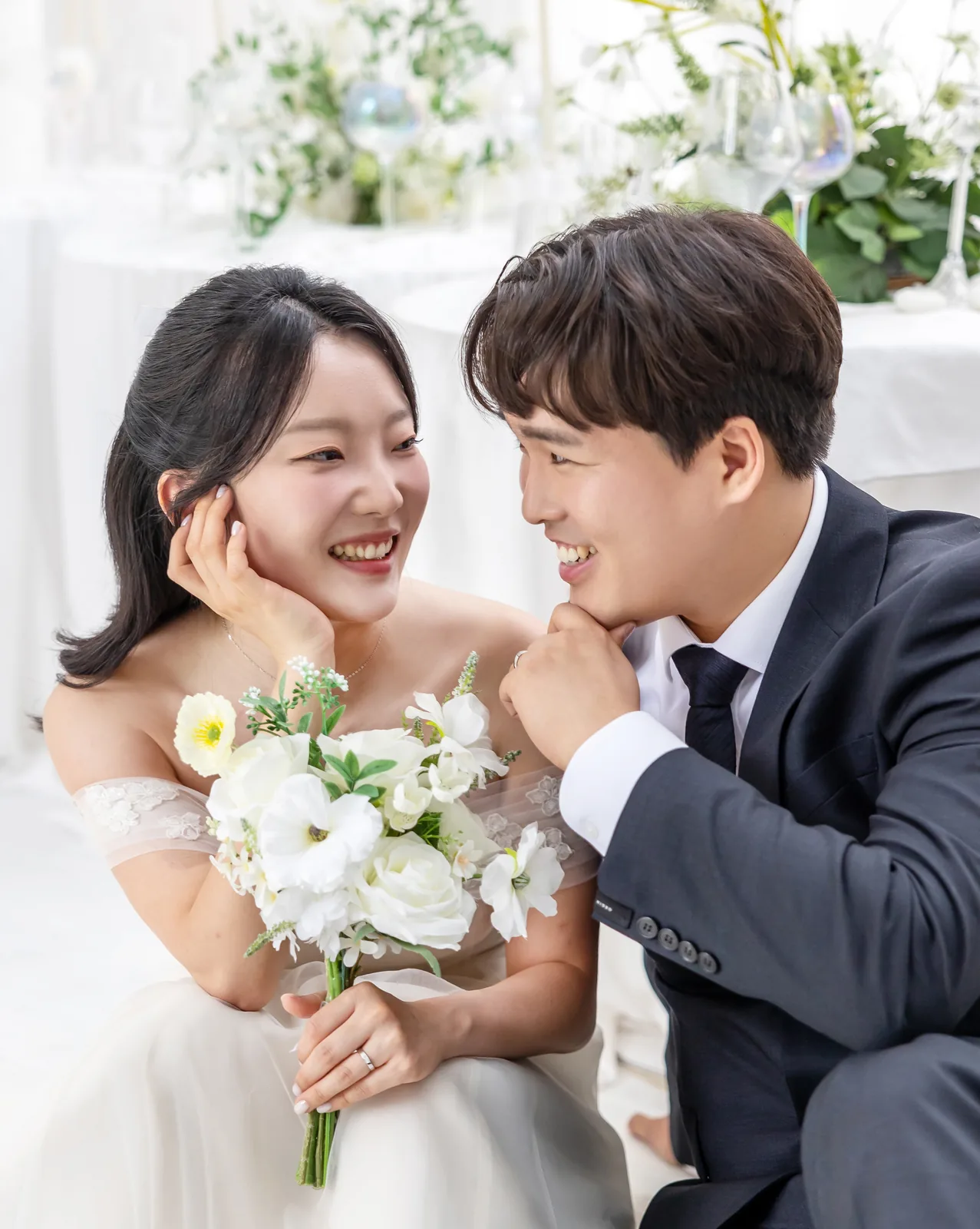 꽃다발을 들고 볼을 맞대듯 웃는 두 사람