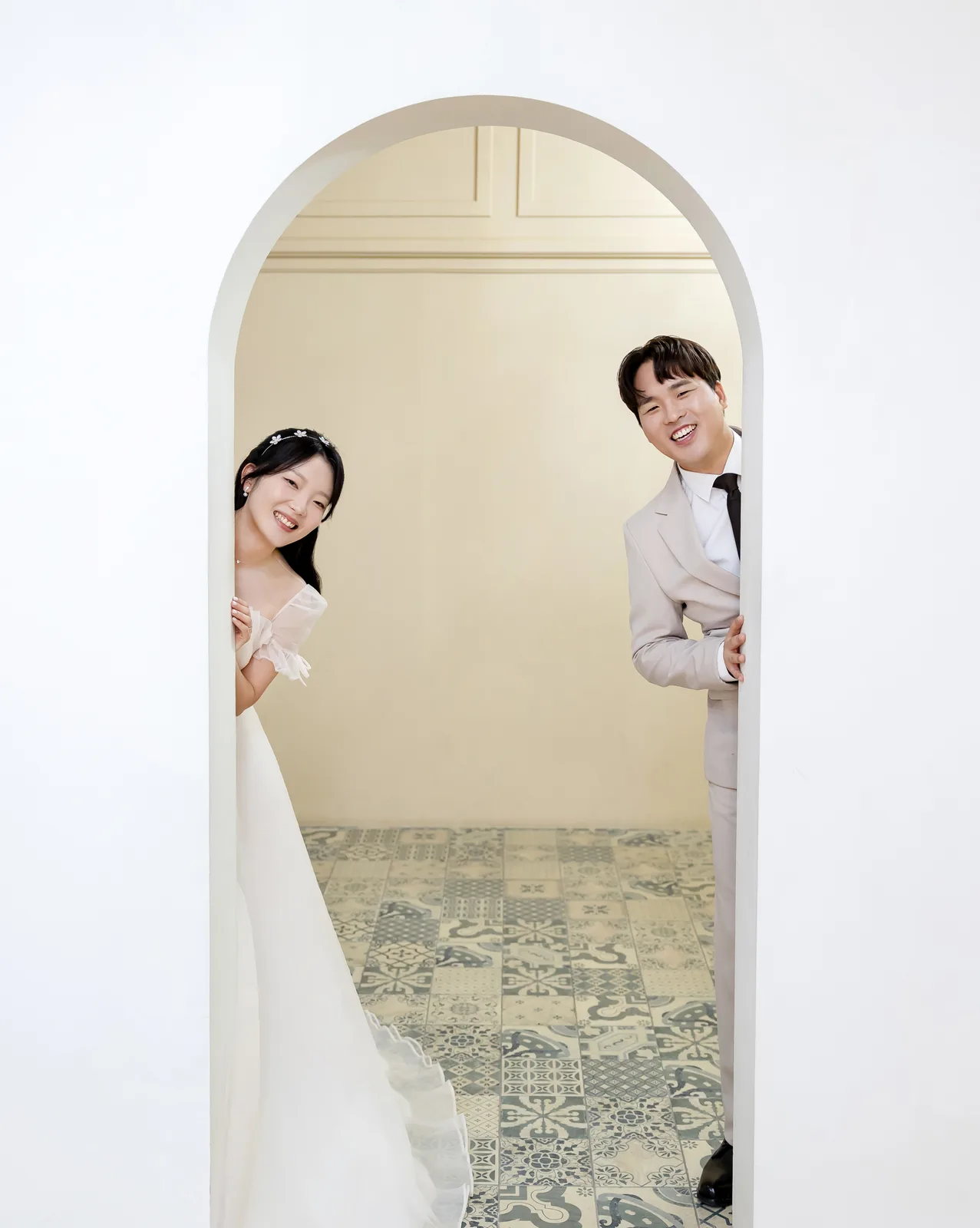 아치 문 양쪽에서 얼굴을 내민 두 사람