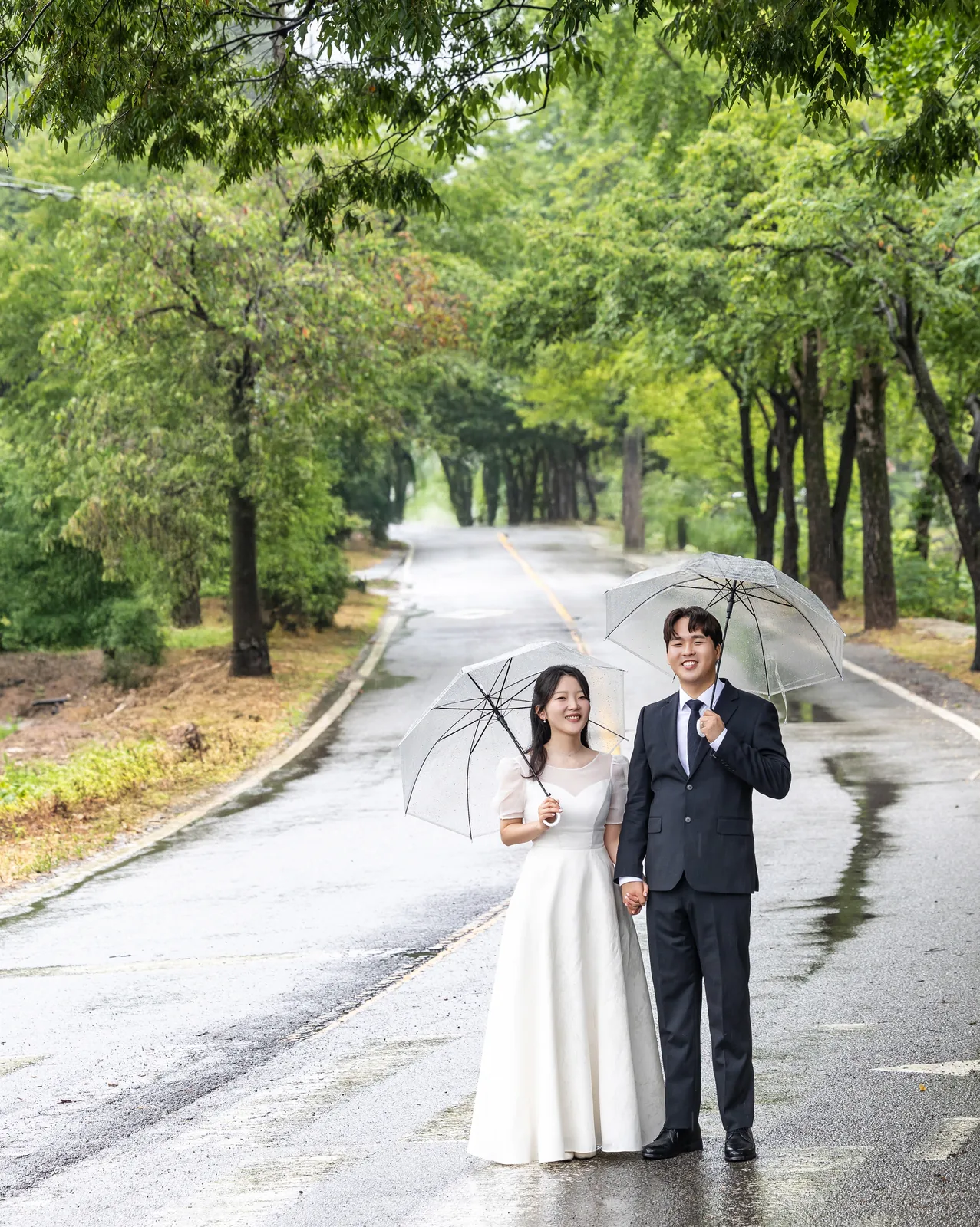 비 내린 숲길 위에 나란히 선 두 사람